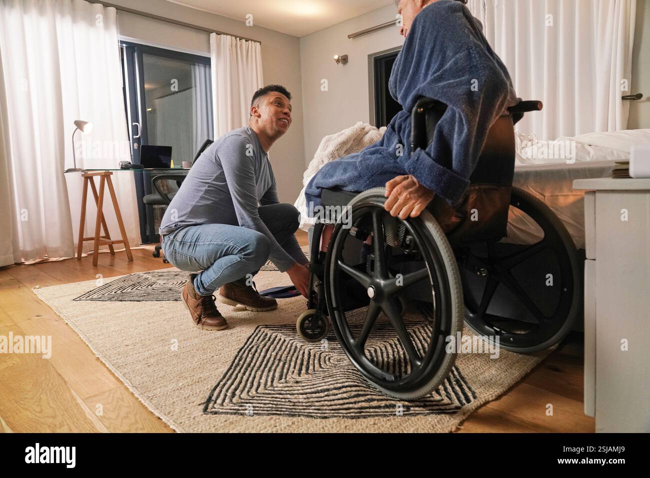 Homme aidant un ami handicapé assis dans un fauteuil roulant Banque D'Images