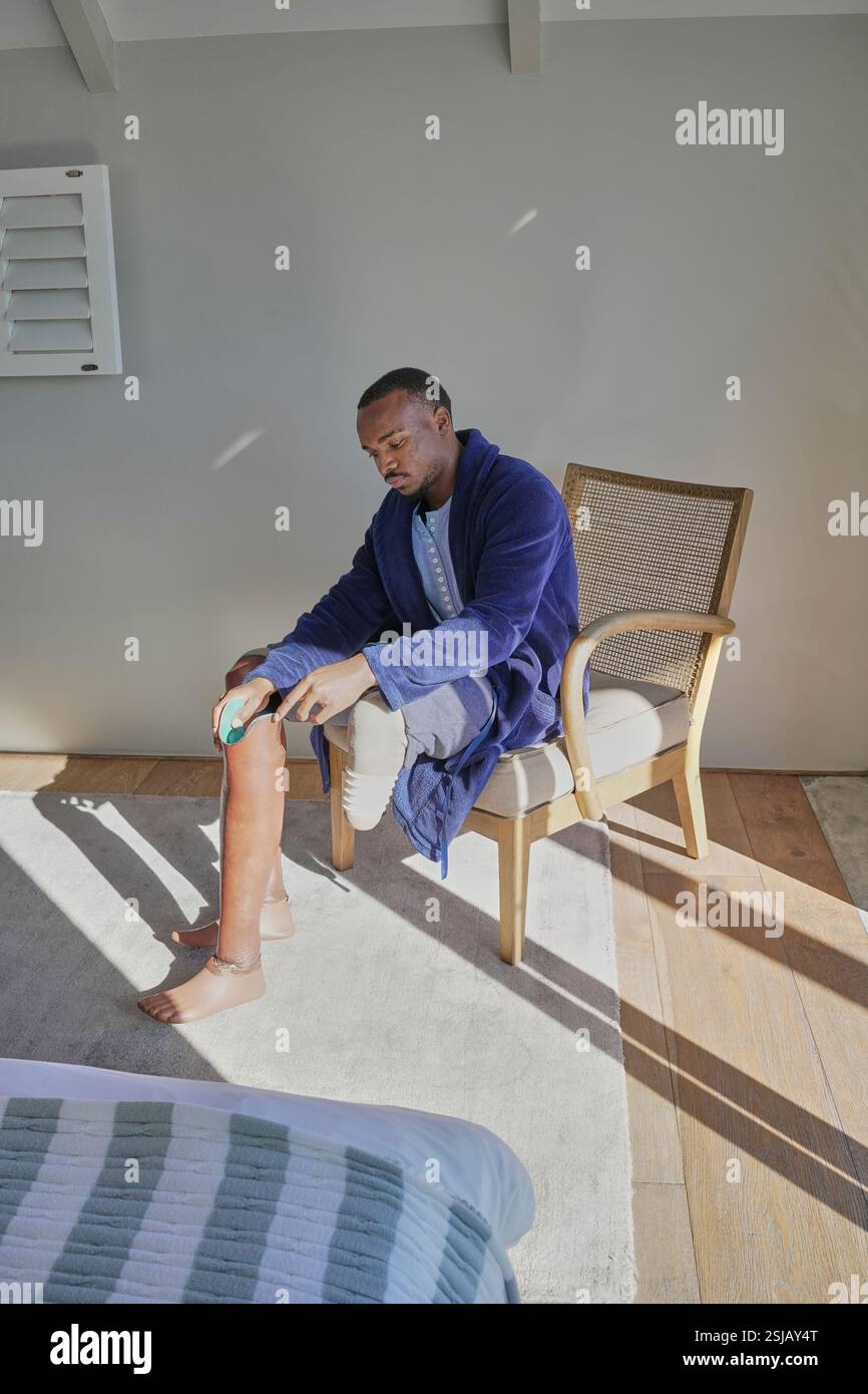 Homme avec prothèse de jambe assis sur une chaise Banque D'Images