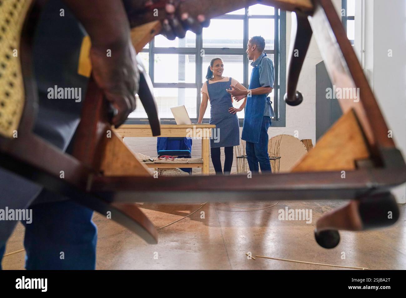 Deux artisans fabriquant des meubles tissés en atelier Banque D'Images