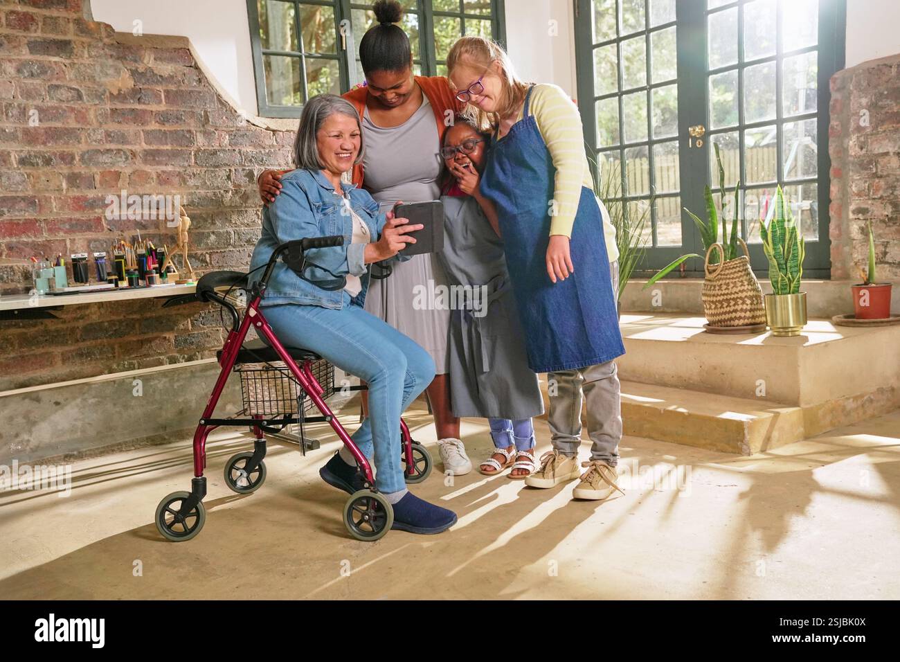 Femmes handicapées regardant une tablette numérique dans un studio d'art. Banque D'Images