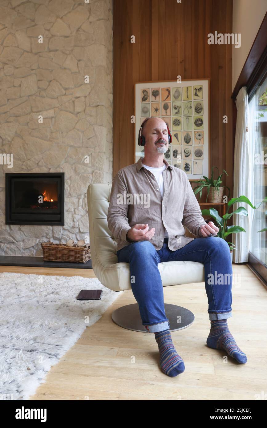 Homme assis dans un fauteuil et méditant Banque D'Images