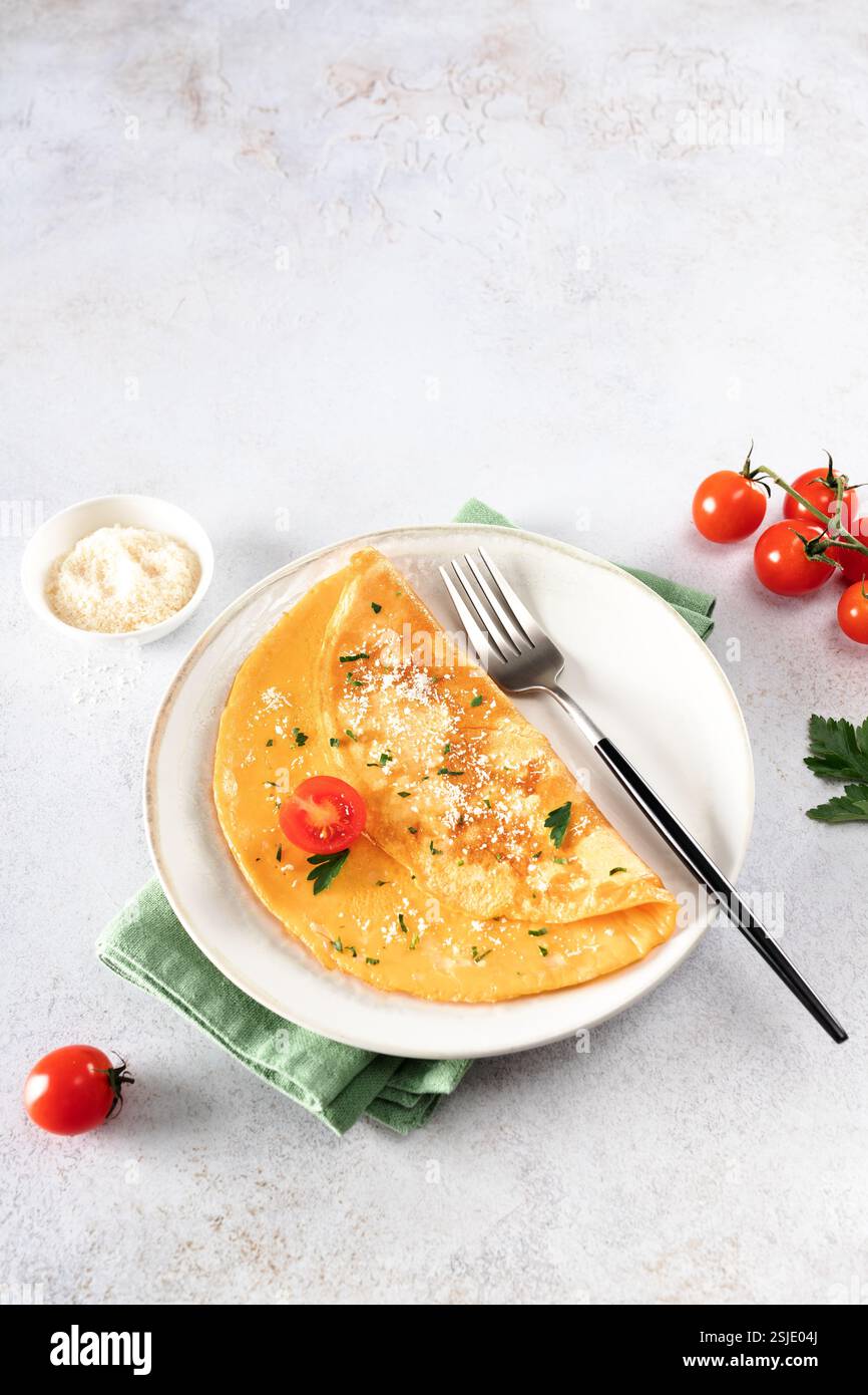 Omelette aux œufs avec fromage, tomate et persil sur fond blanc. Copier l'espace. Banque D'Images