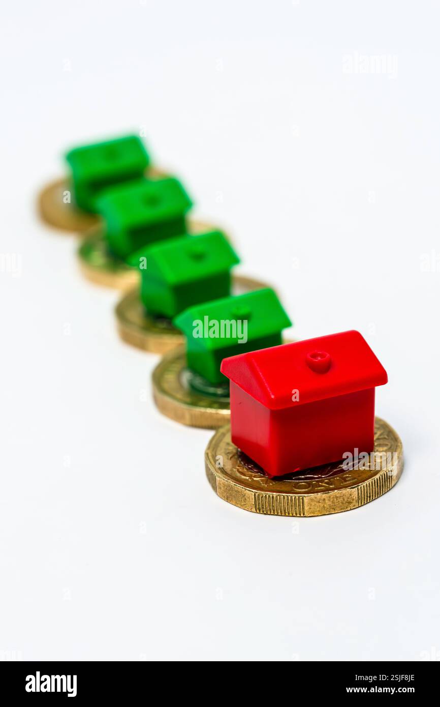 Concept d'investissement immobilier avec des maisons placées sur des pièces de monnaie dans une longue rangée Banque D'Images