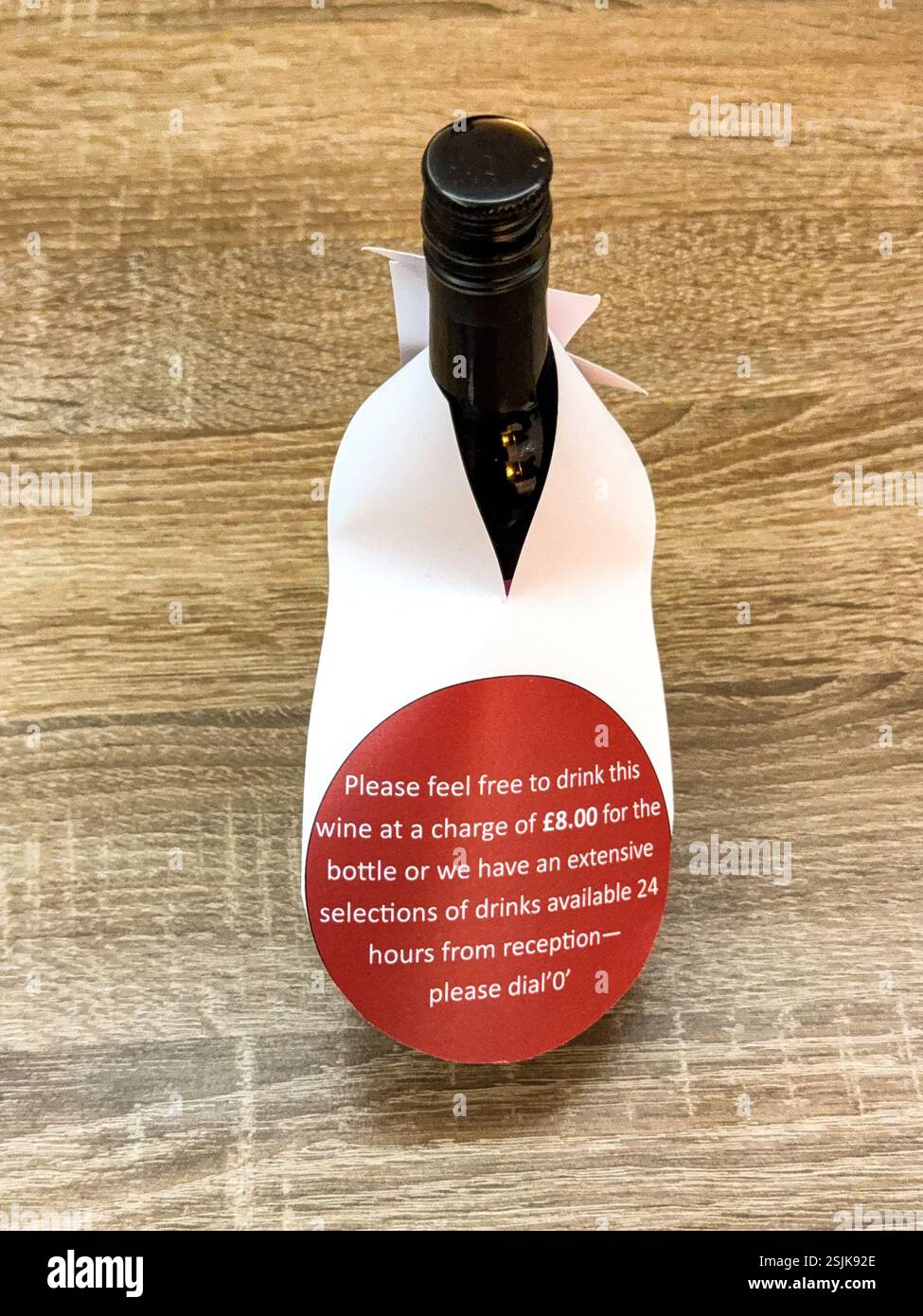 Petit quart de bouteille de vin rouge dans une chambre d'hôtel avec un collier indiquant le prix. Personne. Banque D'Images