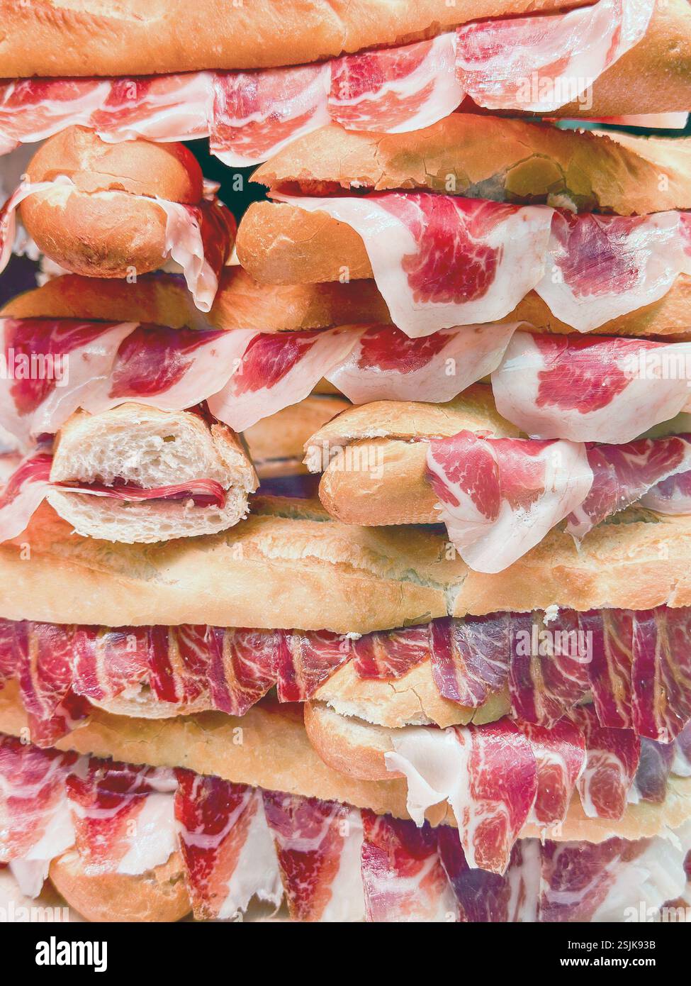 Vue rapprochée de baguettes fraîches remplies d'une fine tranche de jambon serrano dans un traiteur. Personne. Banque D'Images
