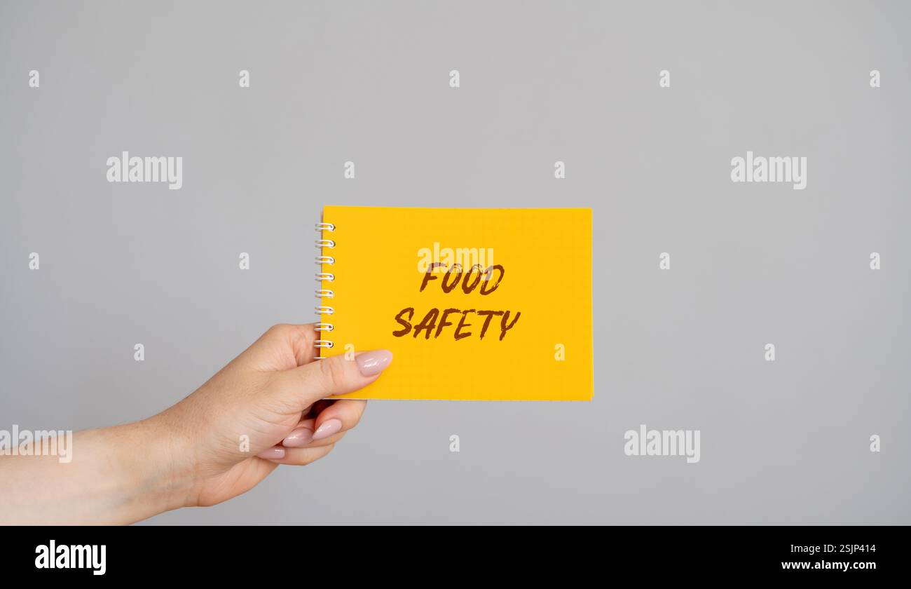 Concept de sécurité alimentaire. L'invention concerne un procédé de manipulation, de préparation et de stockage d'aliments de manière à prévenir les maladies d'origine alimentaire. Une femme tient une note dans ses mains avec Banque D'Images