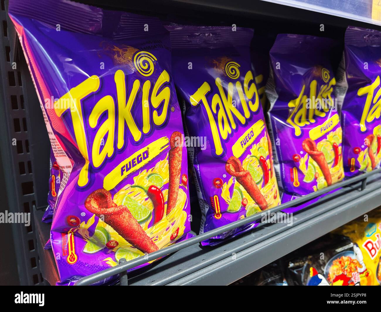 Kiev, Ukraine - 11 février 2025 : sachets de casse-croûte de tortilla épicés mexicains aromatisés Takis disposés sur les étagères des supermarchés Banque D'Images