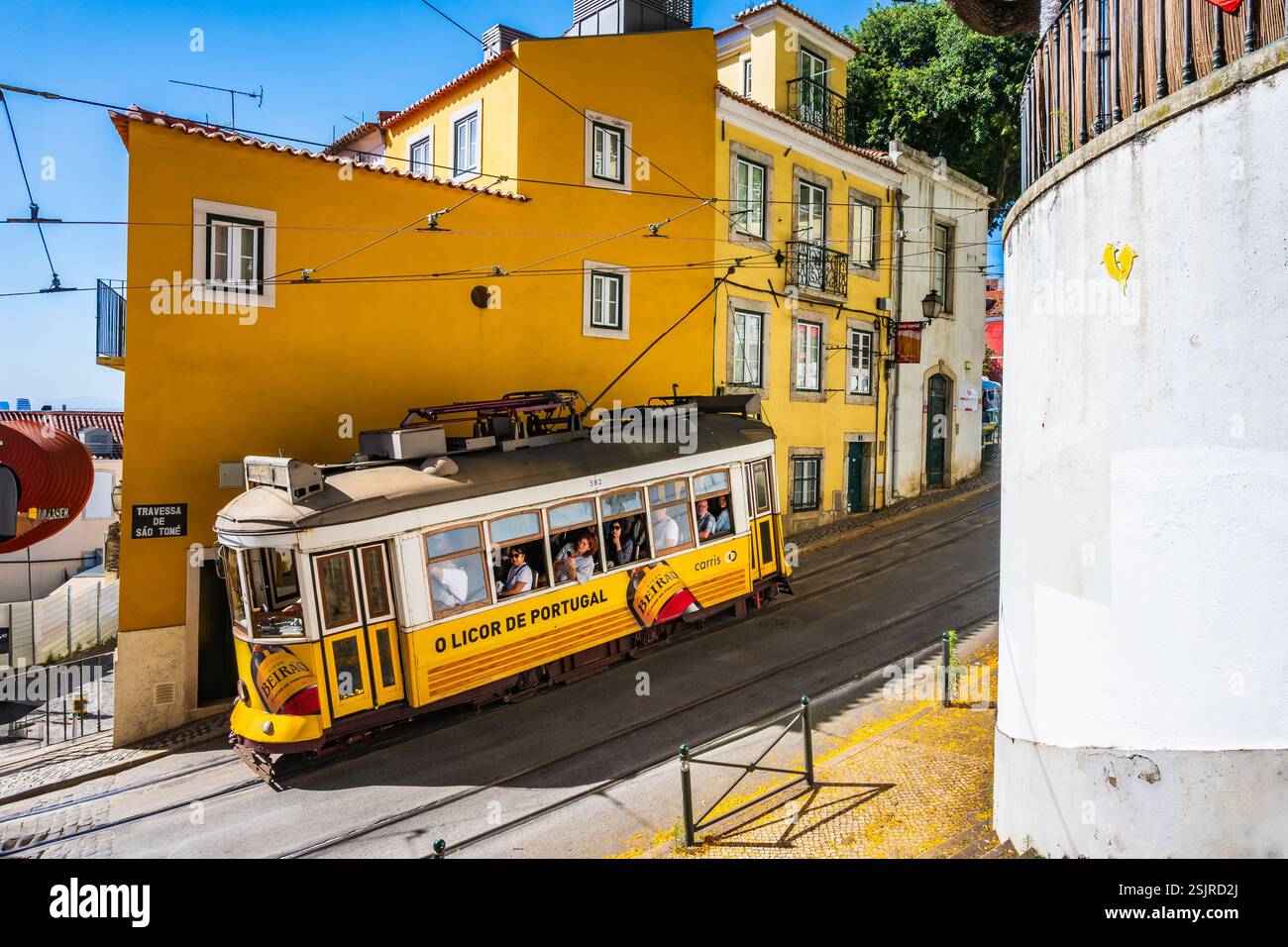 LISBONNE, PORTUGAL - Jun 11, 2024 : vieux tramway jaune n ° 28 pendant son voyage avec les touristes à travers la vieille ville de Lisbonne, quartier Alfama. Banque D'Images