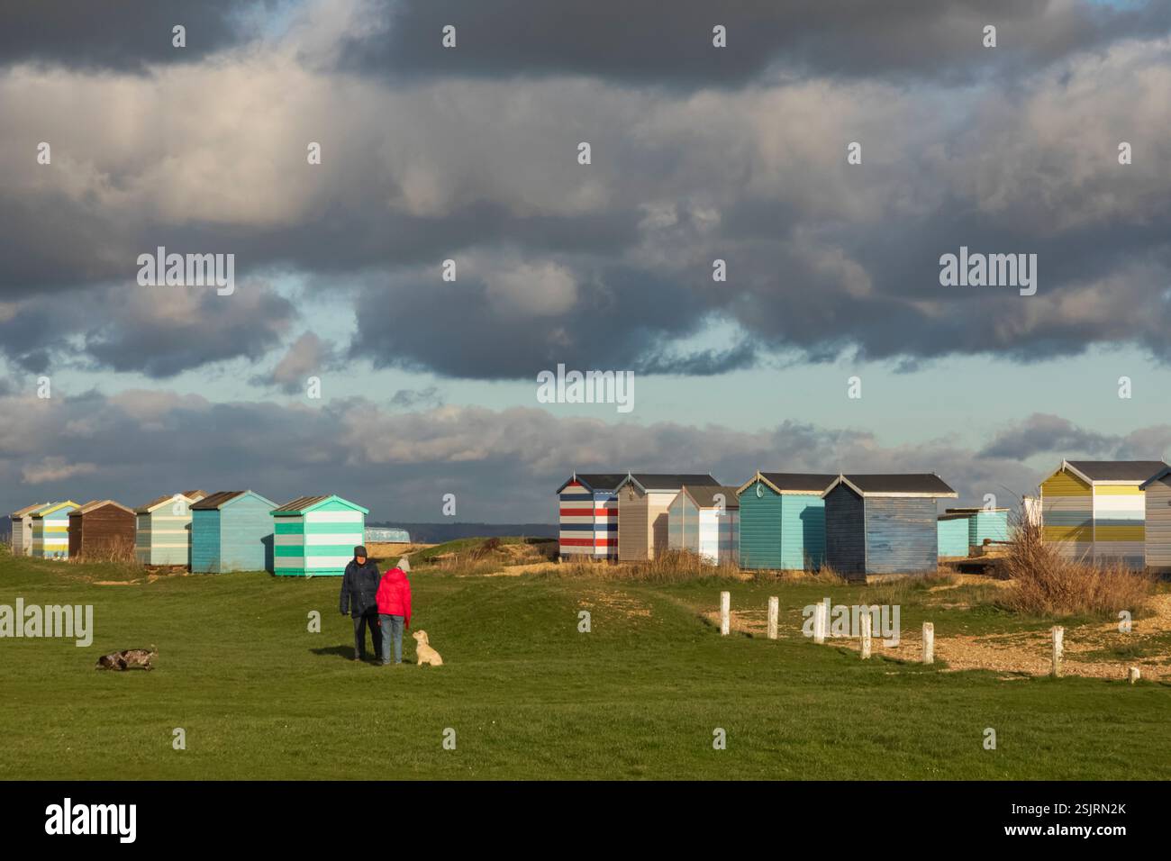 Angleterre, Kent, Romney Marsh, Littlestone Beach, Beach Huts et Dog Walkers Banque D'Images