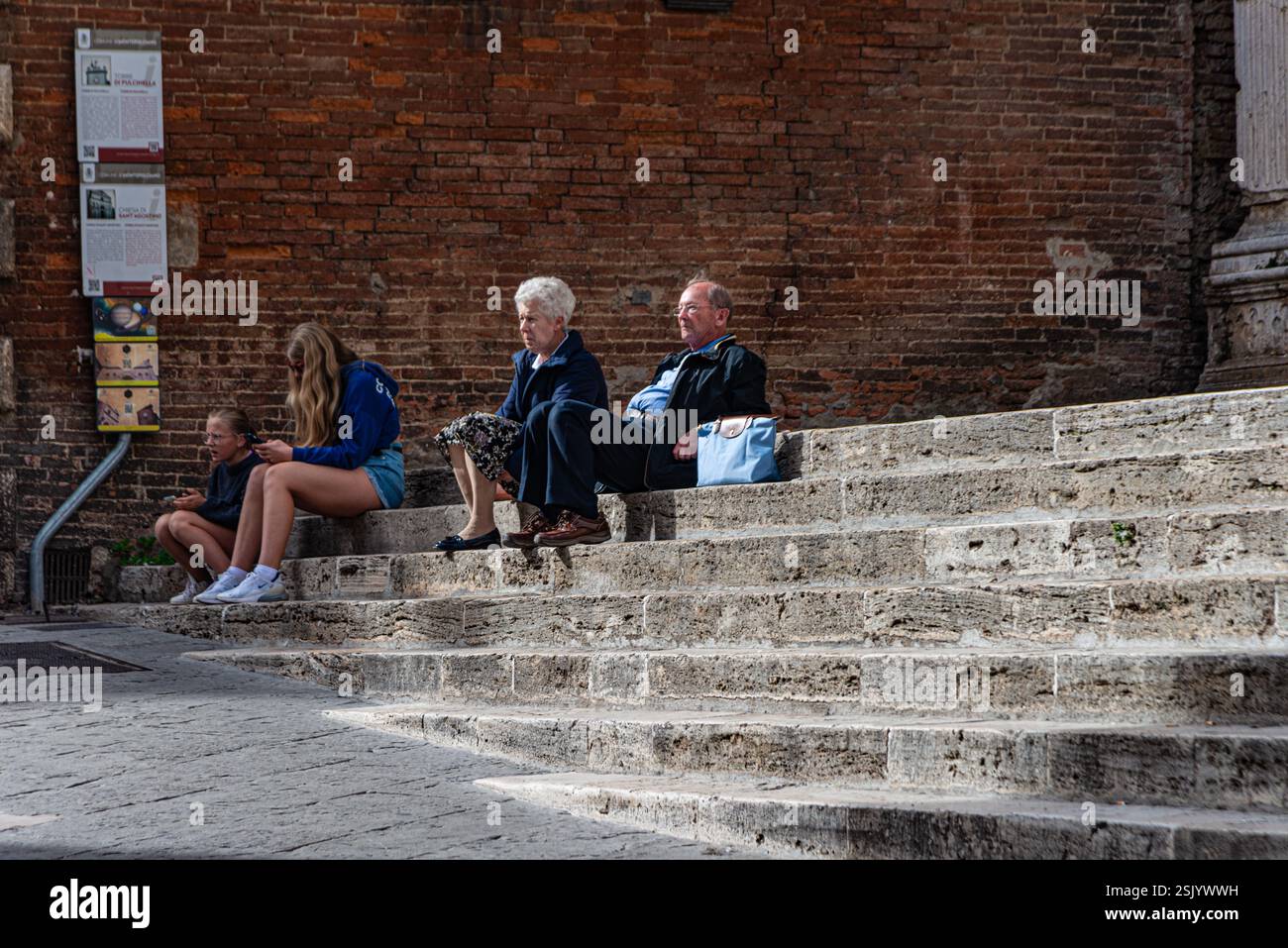 Touristes se relaxant sur les marches à Montepulciano, Italie Banque D'Images
