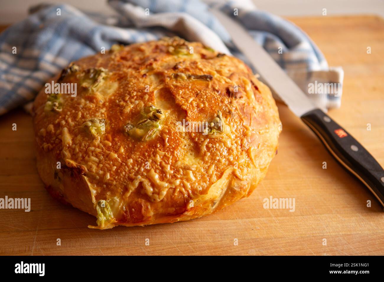 Pain au fromage Bacon Jalapeño fait maison sur une planche à découper en bois avec un couteau à pain Banque D'Images