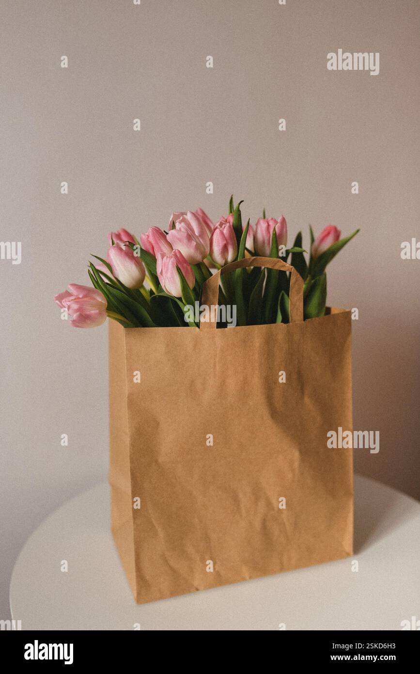 Un beau bouquet de tulipes roses est placé à l'intérieur d'un sac en papier kraft rustique. Banque D'Images