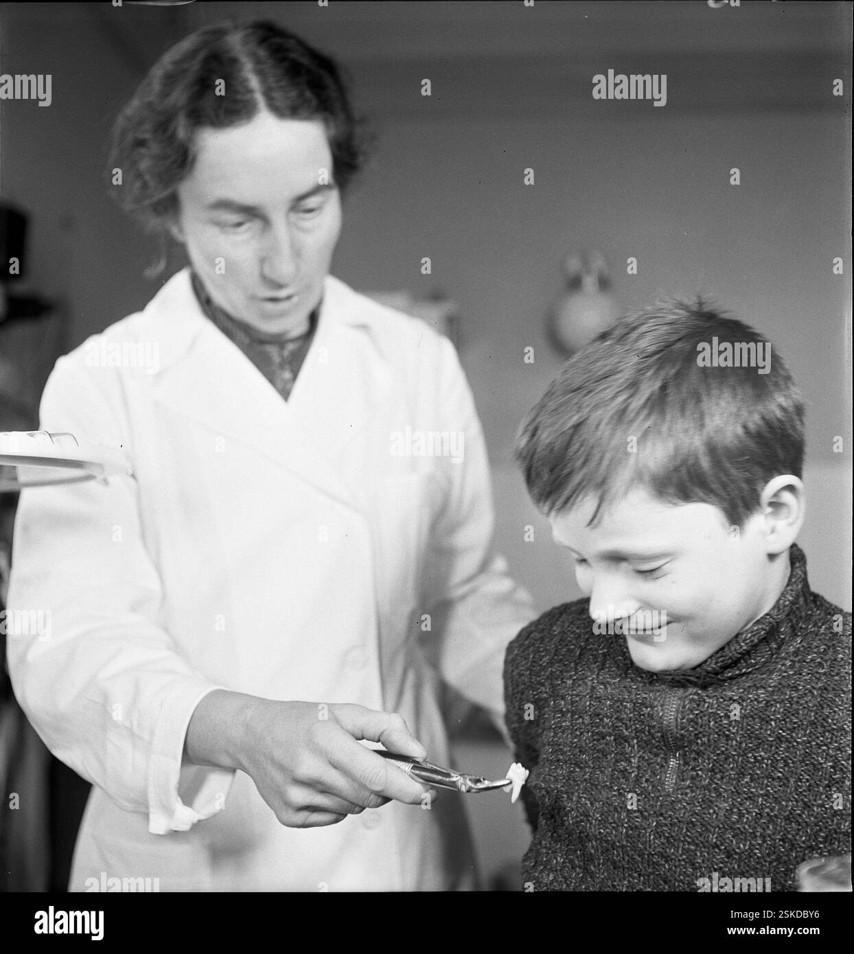 --- Junge betrachtet den ihm gezogenen Zahn, Schulzahnklinik um 1955#Boy regardant une dent extraite, dentisterie scolaire vers 1955- RDB PAR DUKAS Banque D'Images