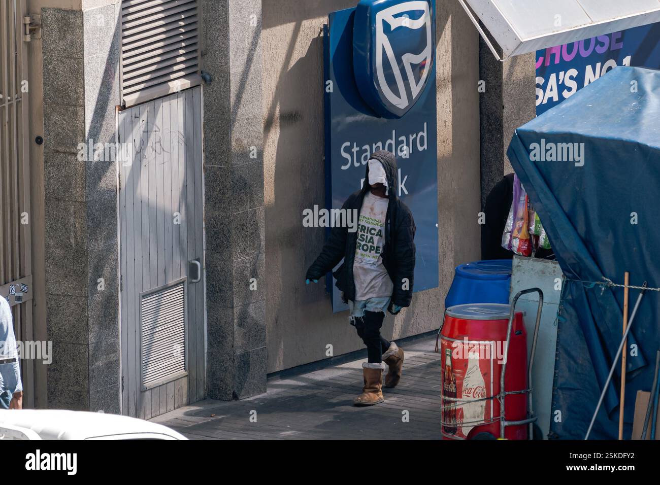 Un Africain sans-abri vêtu d'étranges vêtements descend la rue. Le Cap, Afrique du Sud - 31 OCT 2023 Banque D'Images