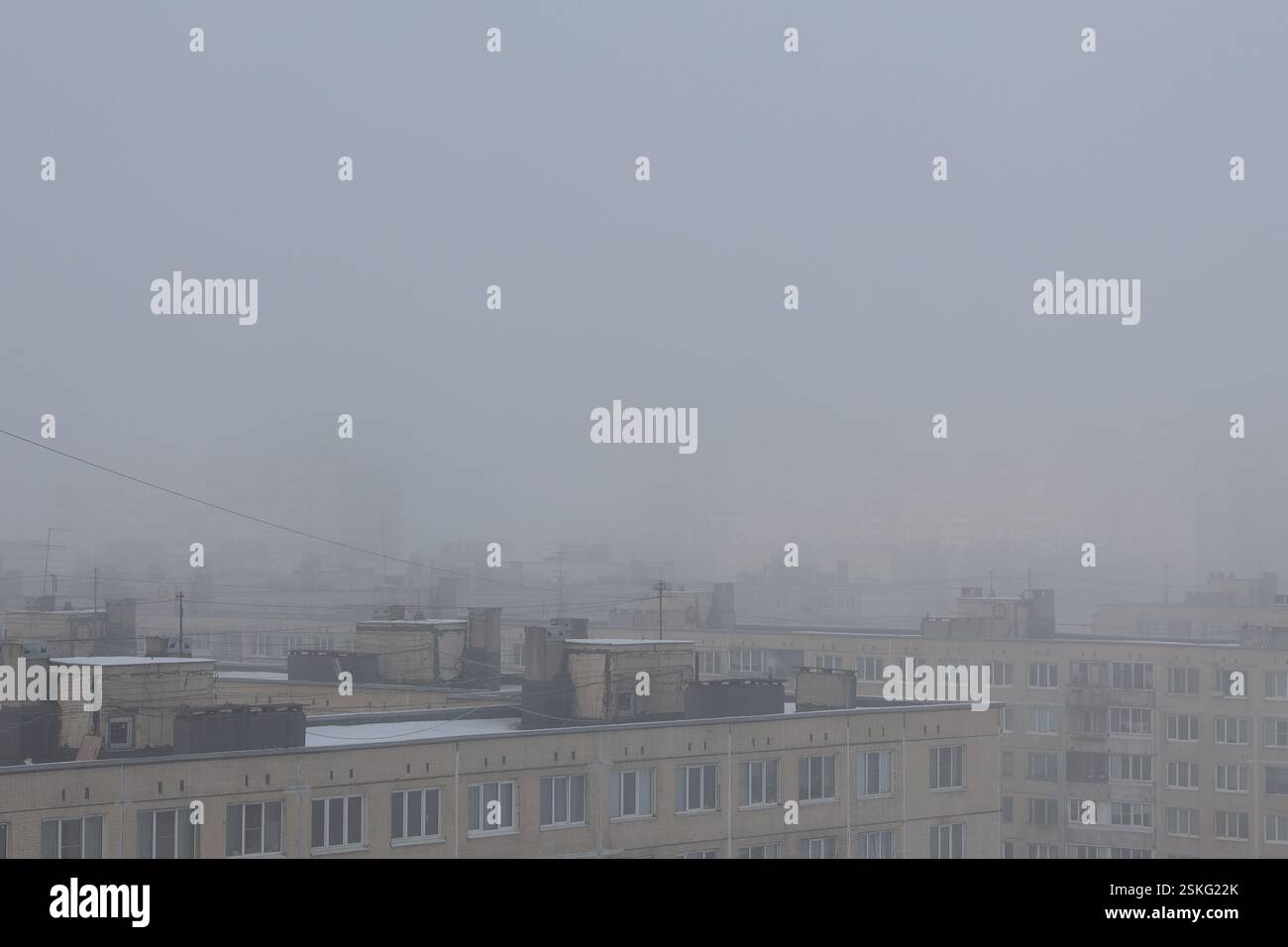 Épais brouillard hivernal sur les toits de vieilles maisons typiques à plusieurs étages Banque D'Images