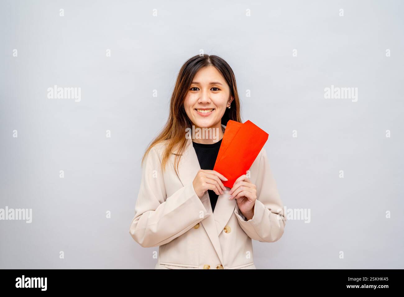Fille de Taïwan tenant une enveloppe rouge avec de l'argent, paquet rouge du nouvel an lunaire avec argent, bonus et concept de salaire - succès financier et richesse Banque D'Images