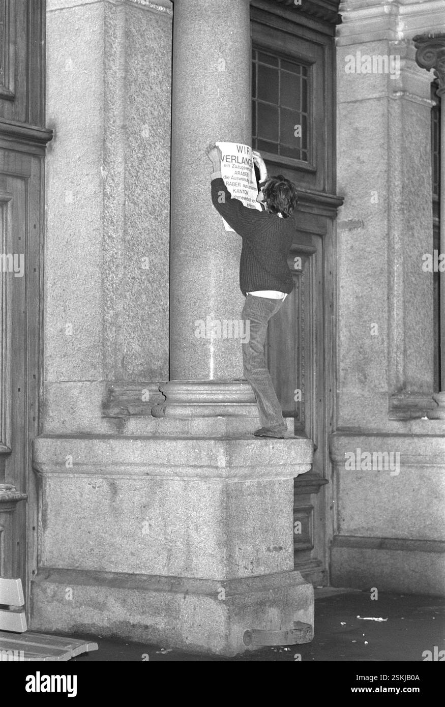 Aktivist klebt Poster mit dem texte : 'Wir verlangen ein Zuzugsverbot für Araber, die Ausweisung aller Araber aus unserem Kanton, Aufnahmeverbot von Arabern in Hotels und BEI Privaten. Legion für die Reinhaltung unseres Kantons'#activiste colle l'affiche : 'nous exigeons une interdiction d'immigration pour les Arabes, l'expulsion de tous les Arabes de notre canton, l'interdiction de recevoir des invités arabes dans les hôtels et en privé. Signé par la Légion pour la purification de notre canton'--- Protest-Aktion gegen Araber im Kanton Lucerne 1970#action de protestation contre les Arabes dans le canton de Lucerne 1970- RDB PAR DUKAS Banque D'Images