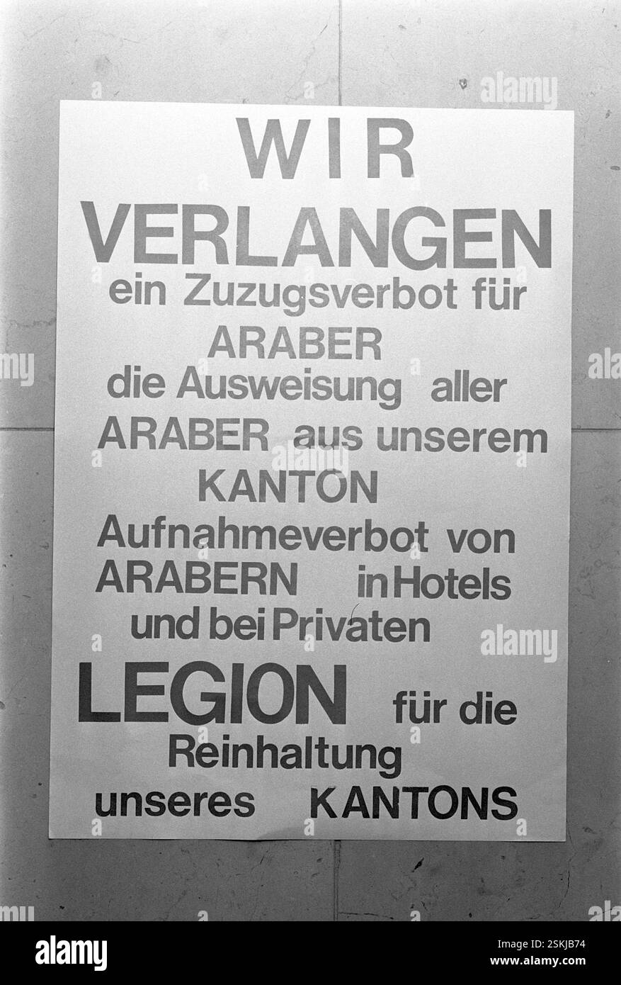 Aktivist klebt Poster mit dem texte : 'Wir verlangen ein Zuzugsverbot für Araber, die Ausweisung aller Araber aus unserem Kanton, Aufnahmeverbot von Arabern in Hotels und BEI Privaten. Legion für die Reinhaltung unseres Kantons'#activiste colle l'affiche : 'nous exigeons une interdiction d'immigration pour les Arabes, l'expulsion de tous les Arabes de notre canton, l'interdiction de recevoir des invités arabes dans les hôtels et en privé. Signé par la Légion pour la purification de notre canton'--- Protest-Aktion gegen Araber im Kanton Lucerne 1970#action de protestation contre les Arabes dans le canton de Lucerne 1970- RDB PAR DUKAS Banque D'Images