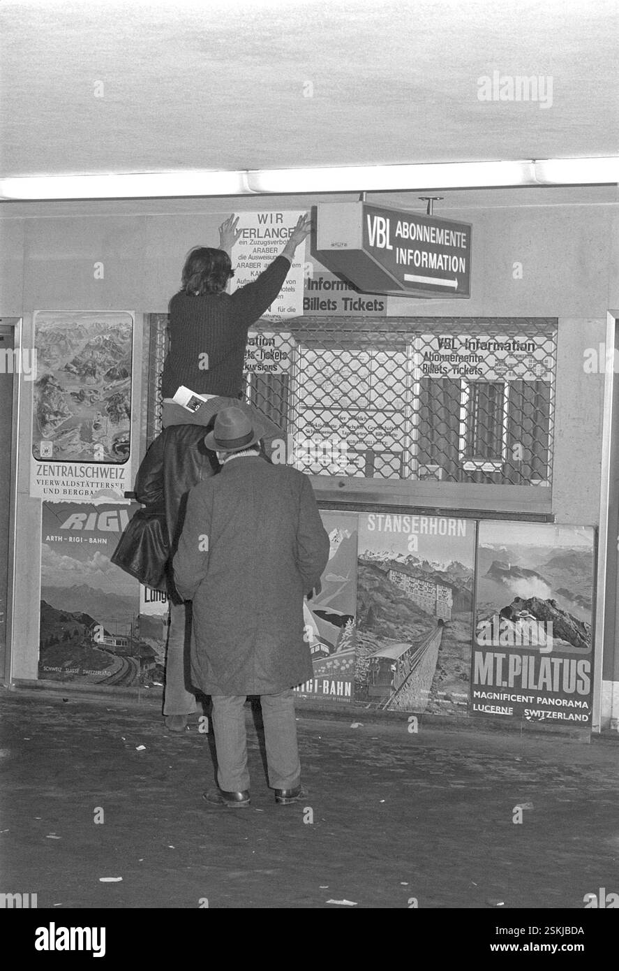 Aktivist klebt Poster mit dem texte : 'Wir verlangen ein Zuzugsverbot für Araber, die Ausweisung aller Araber aus unserem Kanton, Aufnahmeverbot von Arabern in Hotels und BEI Privaten. Legion für die Reinhaltung unseres Kantons'#activiste colle l'affiche : 'nous exigeons une interdiction d'immigration pour les Arabes, l'expulsion de tous les Arabes de notre canton, l'interdiction de recevoir des invités arabes dans les hôtels et en privé. Signé par la Légion pour la purification de notre canton'--- Protest-Aktion gegen Araber im Kanton Lucerne 1970#action de protestation contre les Arabes dans le canton de Lucerne 1970- RDB PAR DUKAS Banque D'Images