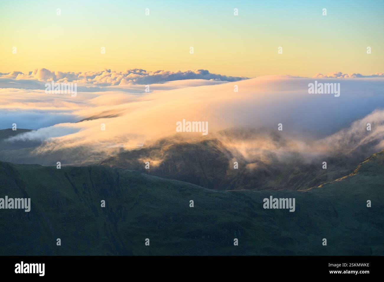 Nuages au-dessus des montagnes par un beau matin ensoleillé vu de Helvellyn dans le Lake District, Royaume-Uni. Banque D'Images