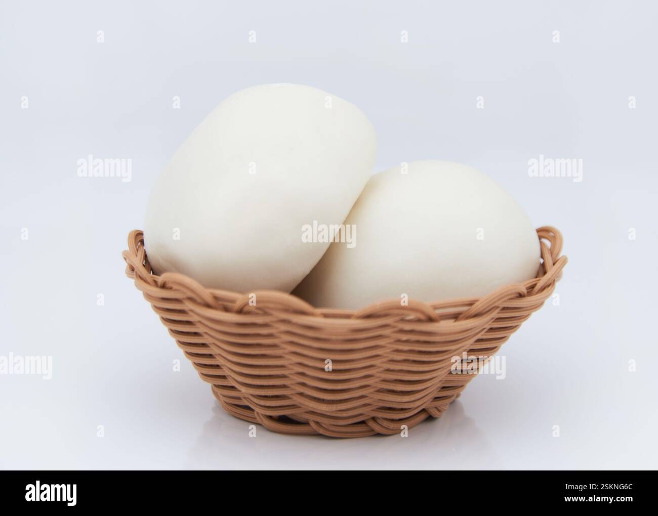 Le petit panier est rempli de petits pains blancs cuits à la vapeur Banque D'Images