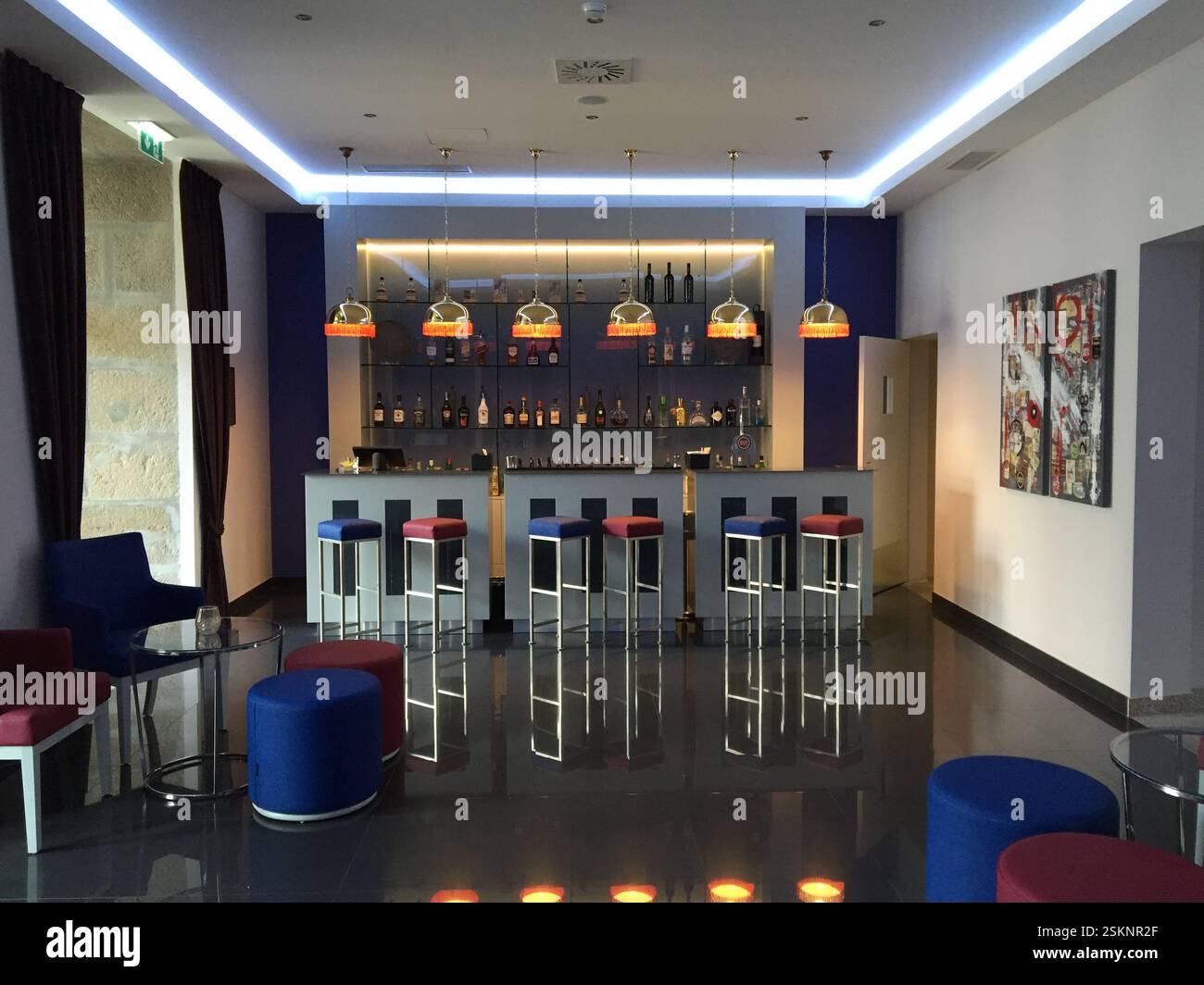 Bar élégant de l'hôtel à Braga, Portugal. Comptoir élégant, sièges confortables, éclairage chaleureux créent une atmosphère accueillante propice à la socialisation et à la détente. Mod Banque D'Images