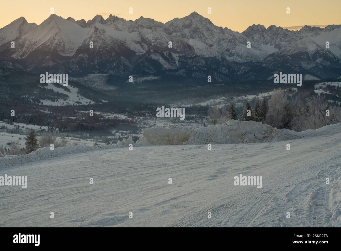 Un parking couvert de neige dans une station de ski dans les montagnes par un matin glacial Banque D'Images