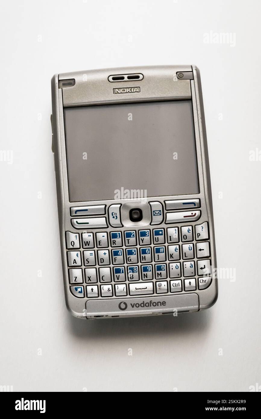 Smartphone Nokia E61 rétro reposant sur un fond blanc, présentant son clavier qwerty et la marque Vodafone Banque D'Images