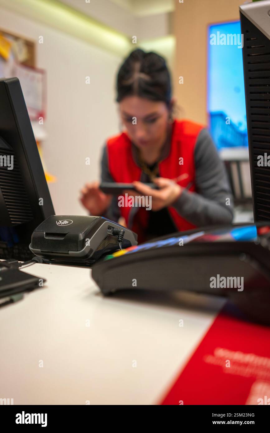 Cremona, Italie - 8 février 2024 vendeuse Vodafone aidant le client à configurer son smartphone dans un magasin Vodafone dynamique, présentant la dernière mab Banque D'Images