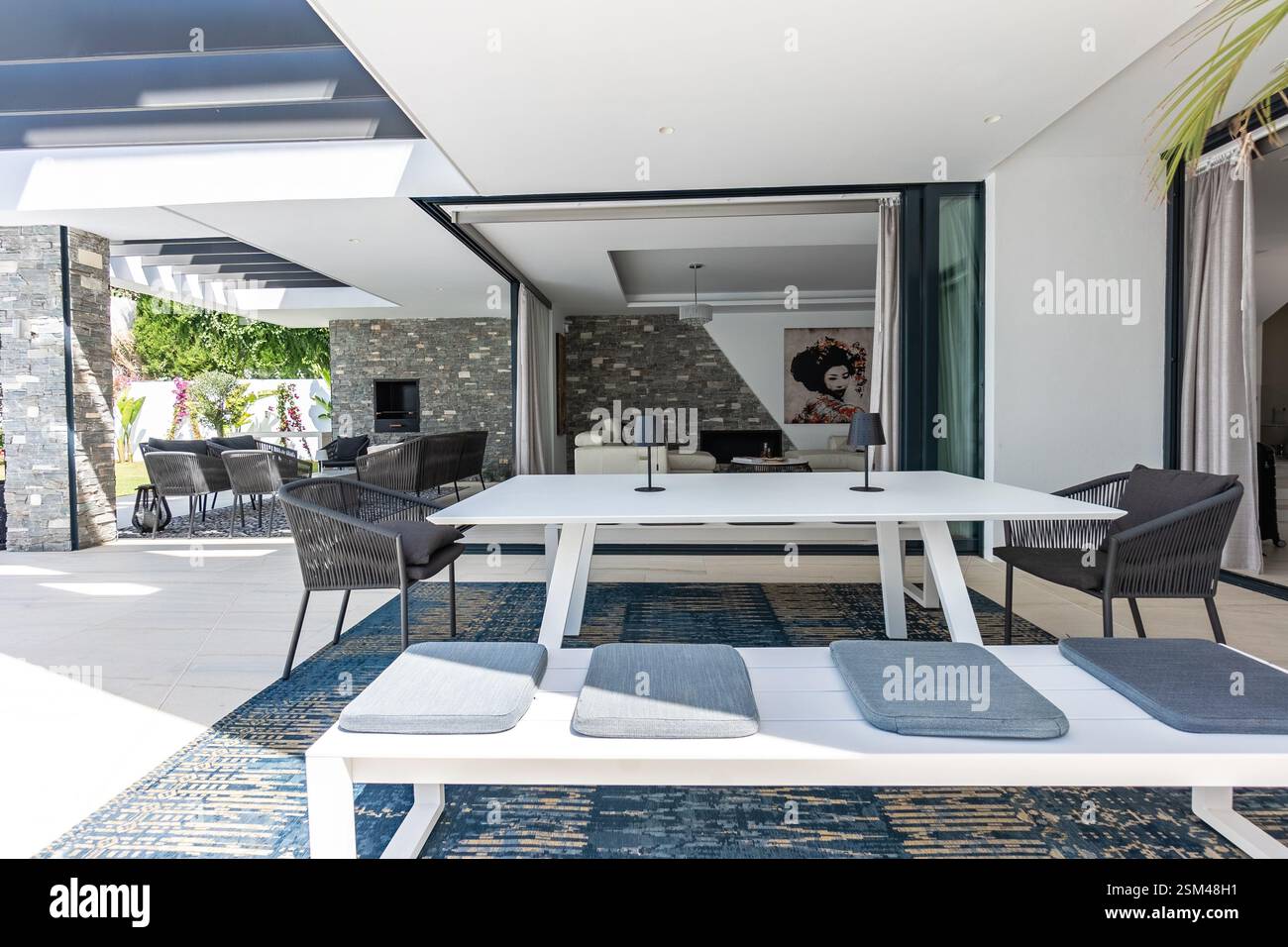 une image rapprochée d'une table à manger extérieure avec des bancs dans la luxueuse maison de vacances méditerranéenne Banque D'Images