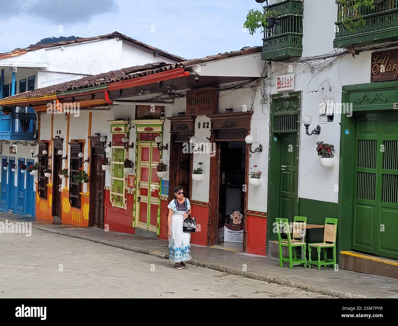 Femme locale marchant devant un bâtiment colonial coloré sur la place principale, jardin, Antioquia, Colombie Banque D'Images