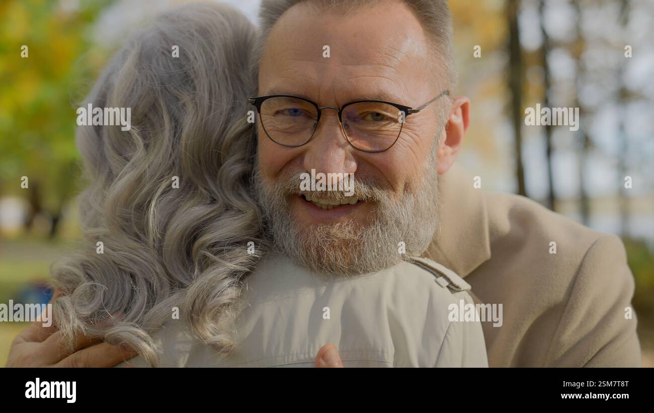 Couple mature embrassant dans le parc d'automne senior cheveux gris 60s homme âgé embrassant femme heureuse famille mariée embrasser embrasser Hug amour soutien de soin romance à vieux Banque D'Images