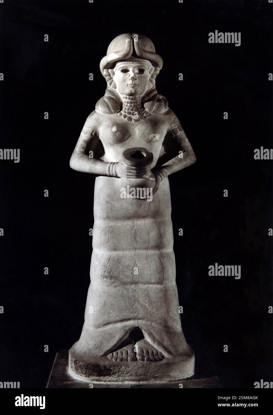Déesse de mari reconstruite à partir de fragments de pierre. La sculpture est désignée par sa coiffe cornée. Un canal mène de ses pieds à la jarre elle h. Banque D'Images