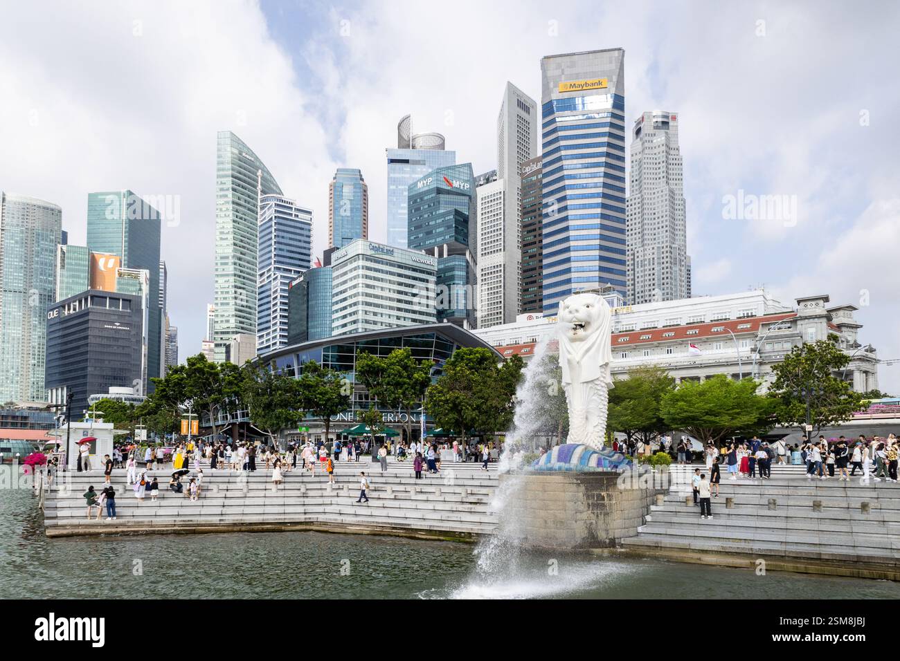 Les touristes apprécient la fontaine Merlion à Singapour, au milieu des gratte-ciels. Banque D'Images
