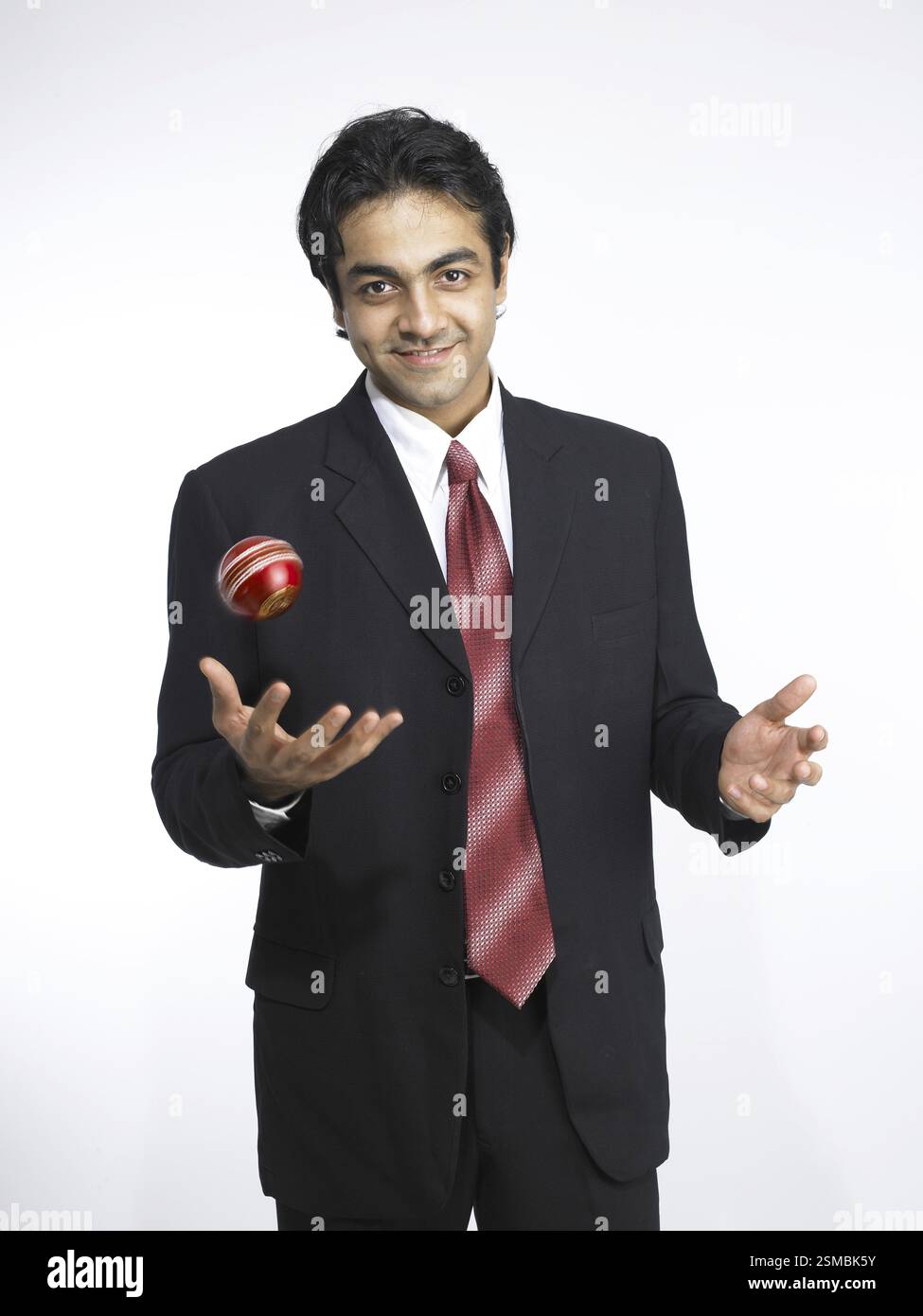 Exécutif indien sud-asiatique lançant une balle de cricket couleur marron MR#702A. Banque D'Images