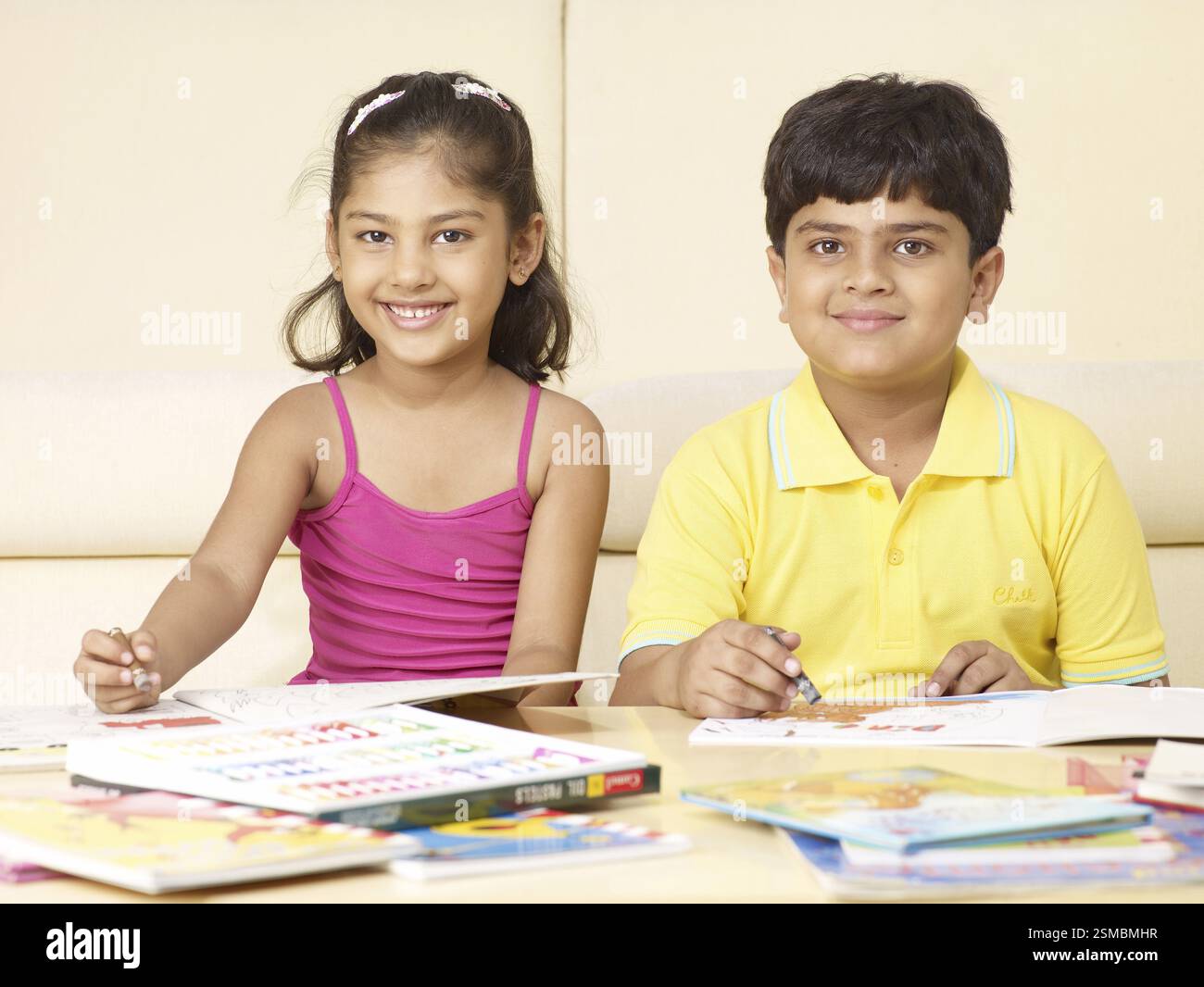 Frère et soeur avec encombrement books siégeant en chambre M.# 702T, M.# 702U Banque D'Images
