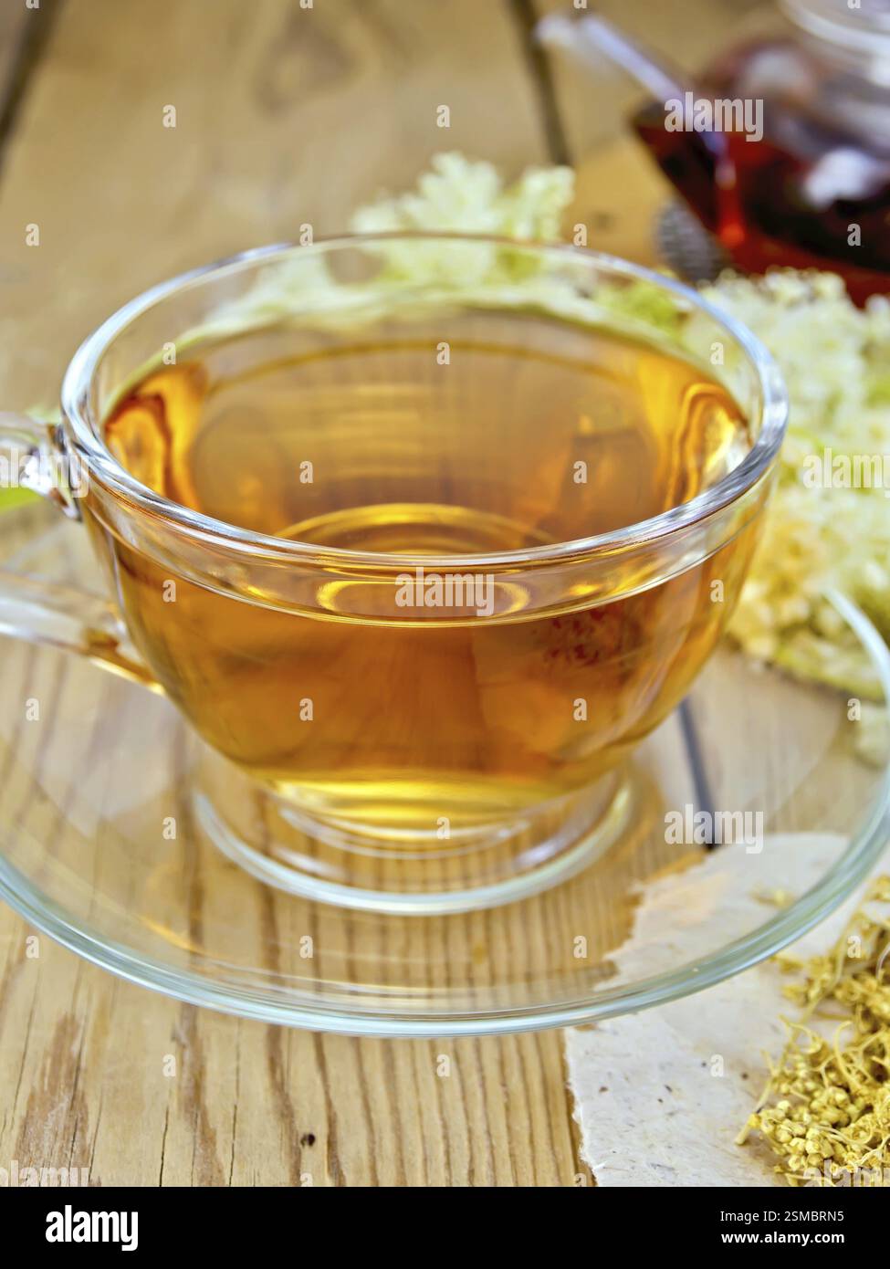 Meadowsucette thé d'une tasse en verre et théière, fleurs séchées sur papier Meadowsucette, fleurs fraîches de Meadowsucette sur une planche de bois Banque D'Images