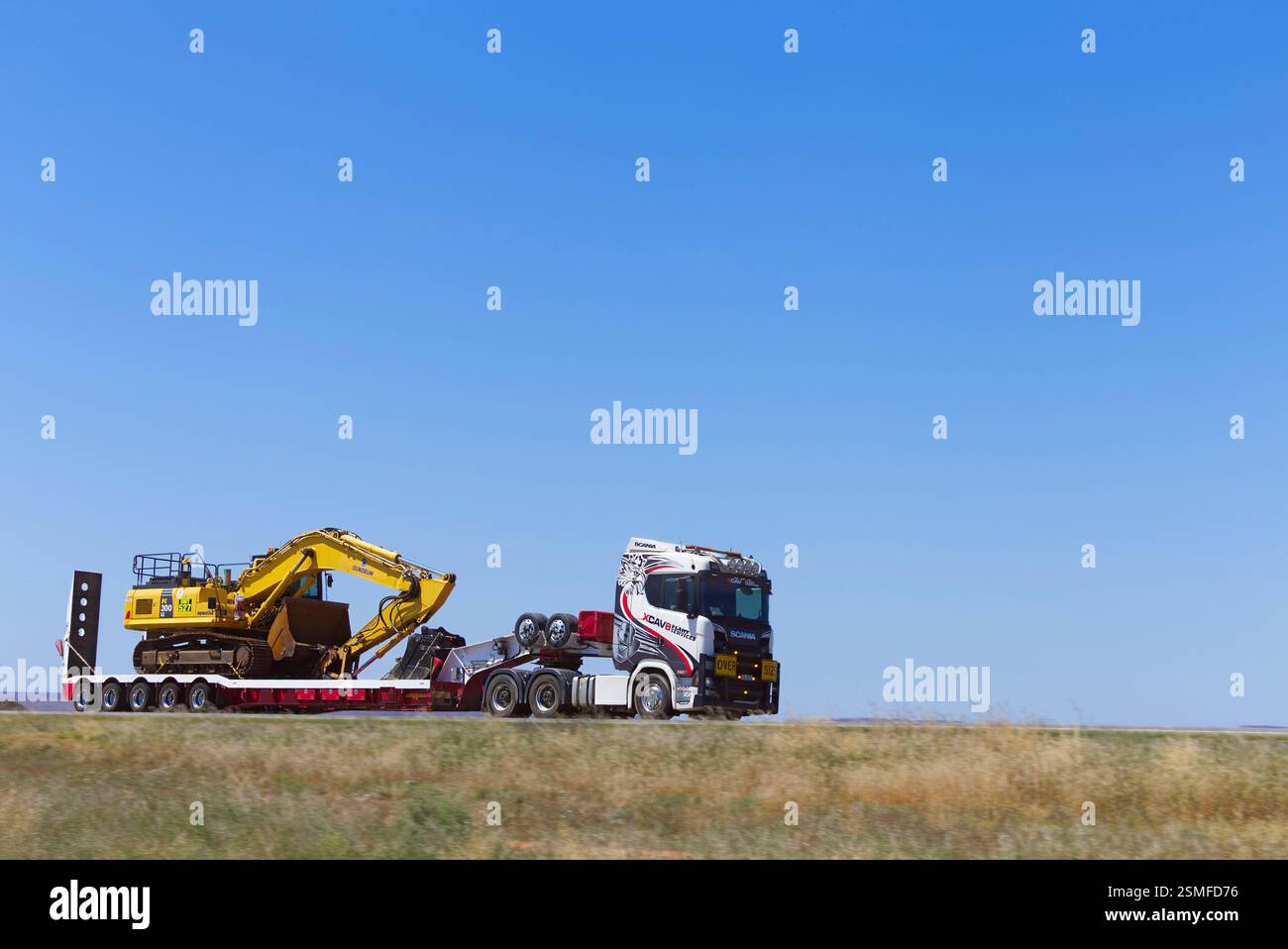 Pelle hydraulique sur remorque surbaissée transportée par un Prime Mover à nez court traversant la Barrier Highway New South Wales Australie Banque D'Images