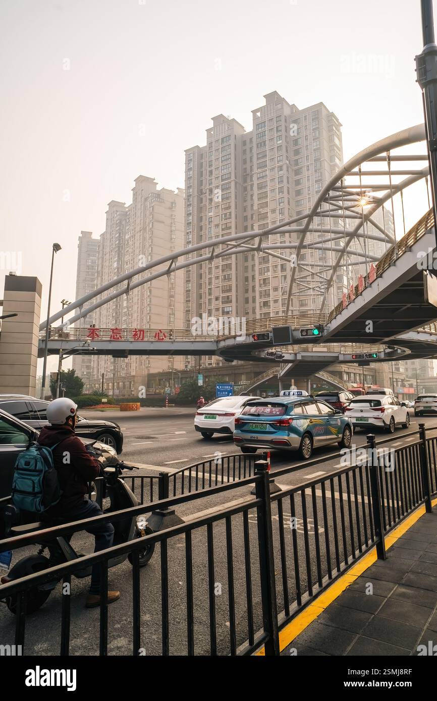 Shanghai, Chine - 7 décembre 2024 piéton traversant la route avec une voiture en attente près du centre SML. Banque D'Images