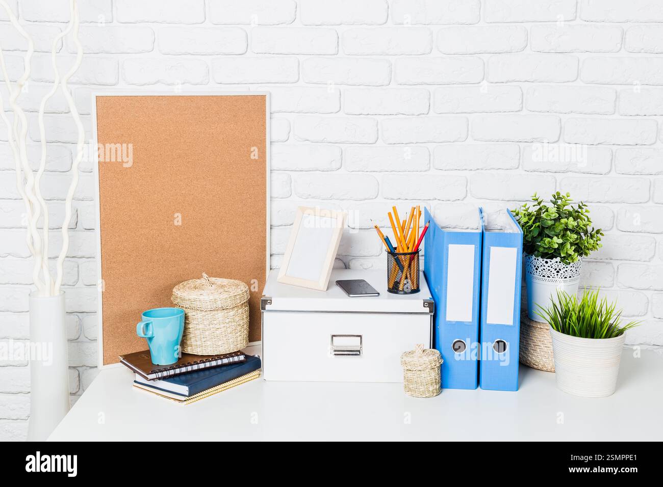 Espace de travail organisé avec des solutions de rangement, de la papeterie et des éléments décoratifs dans un cadre lumineux Banque D'Images