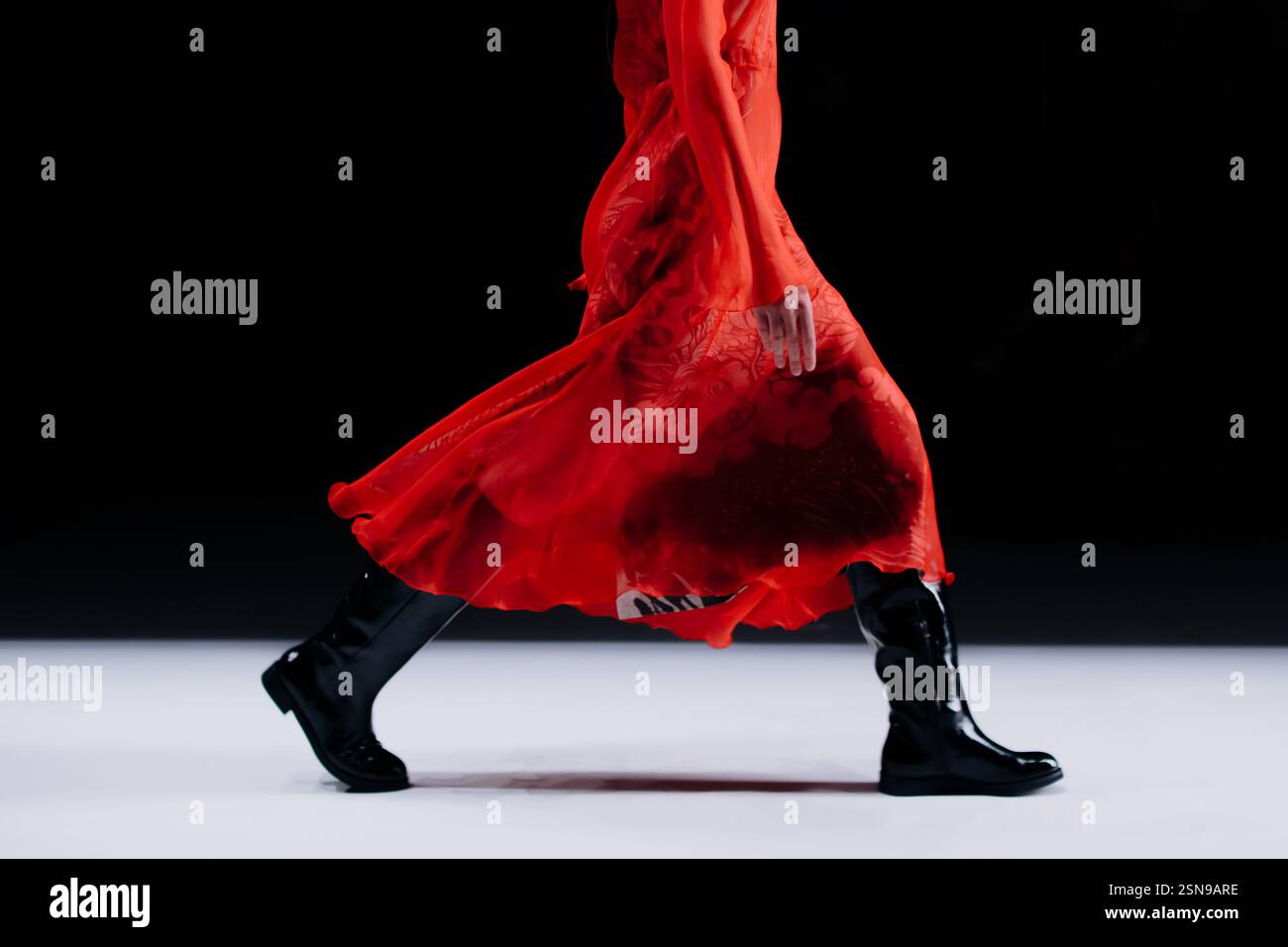 Détails de mode élégants de robe rouge vif et bottes noires, concept de tissu de mode pour femmes sur fond noir, espace de copie Banque D'Images