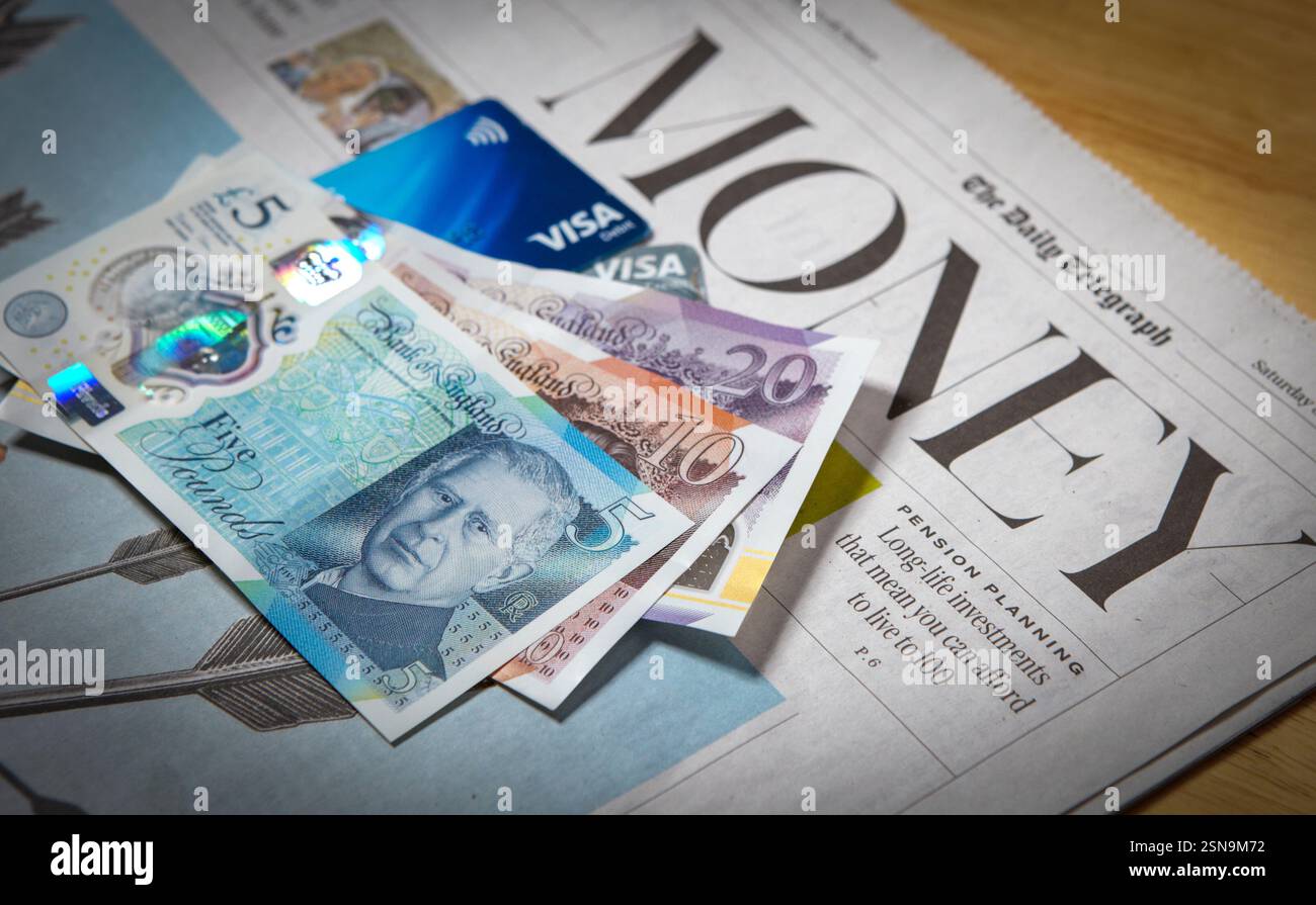 Une sélection de billets de banque britanniques et de cartes Visa dans la section argent et finances d'un journal britannique, février 2025 Banque D'Images