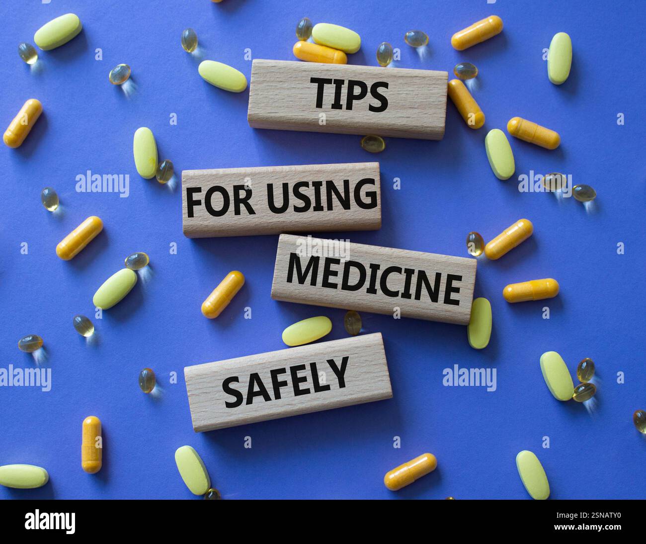 Symbole de médicament. Mot concept prendre des drogues de la bonne façon sur des blocs de bois. Beau fond violet avec des pilules. Concept de médecine. Copier l'espace Banque D'Images