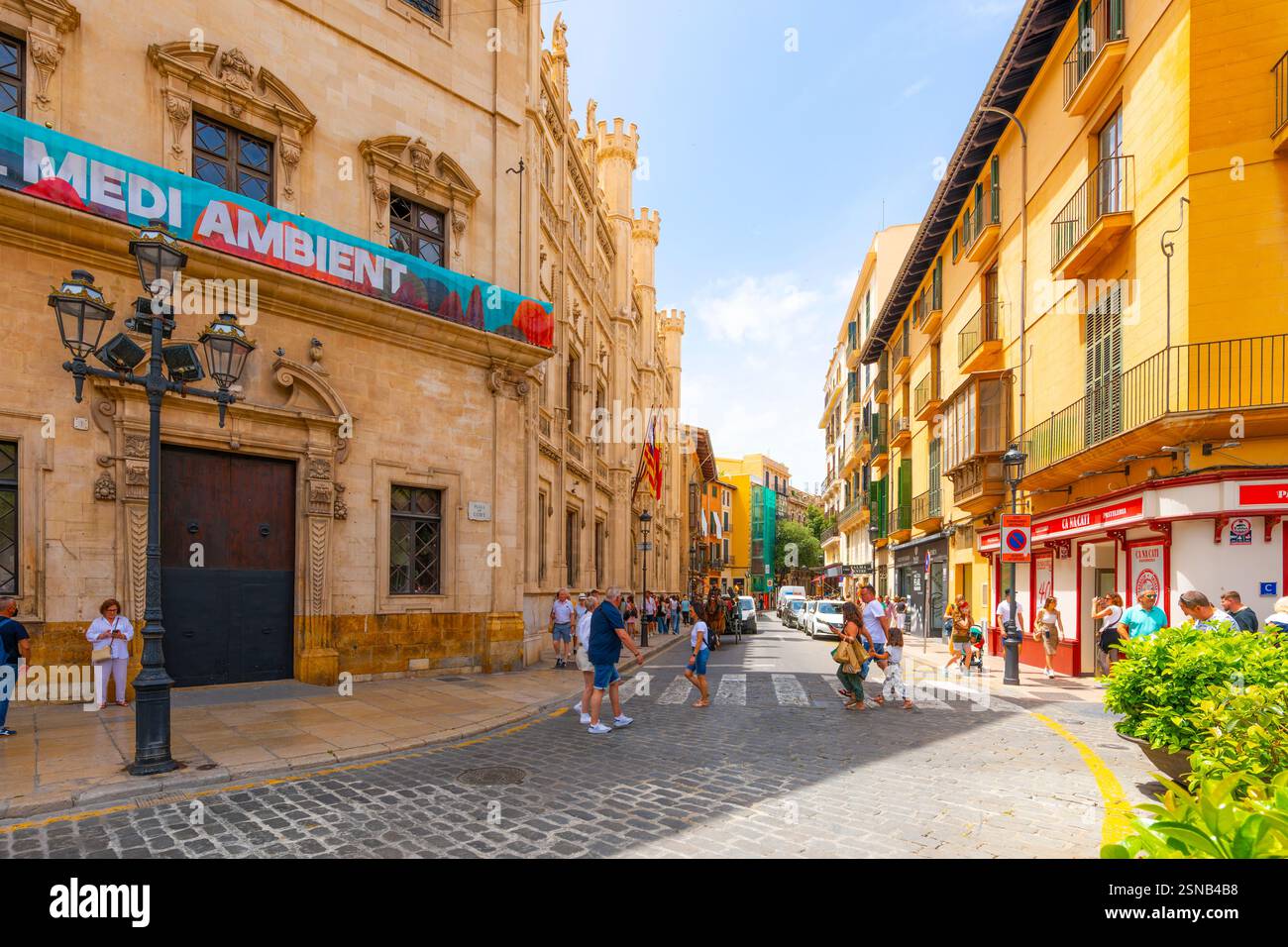 Les touristes passent par l'hôtel de ville sur la place historique de la ville méditerranéenne espagnole de Palma de Majorque, en Espagne, sur l'île de Majorque Banque D'Images
