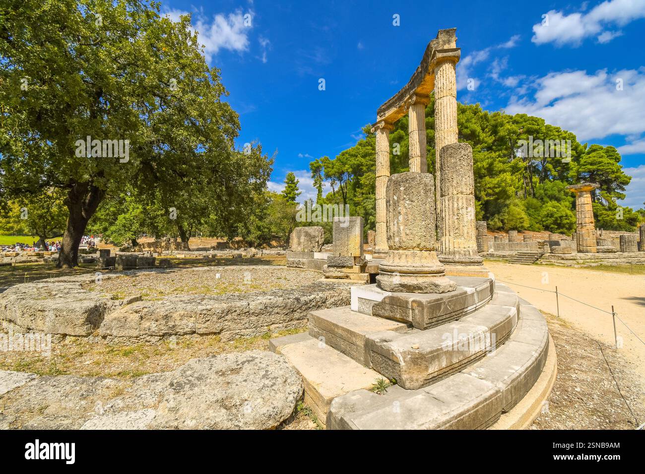 Les touristes visiter l'ancienne Philippeion dans l'Altis d'Olympie, un monument circulaire ionique dans le calcaire et le marbre à Olympie, Grèce. Banque D'Images