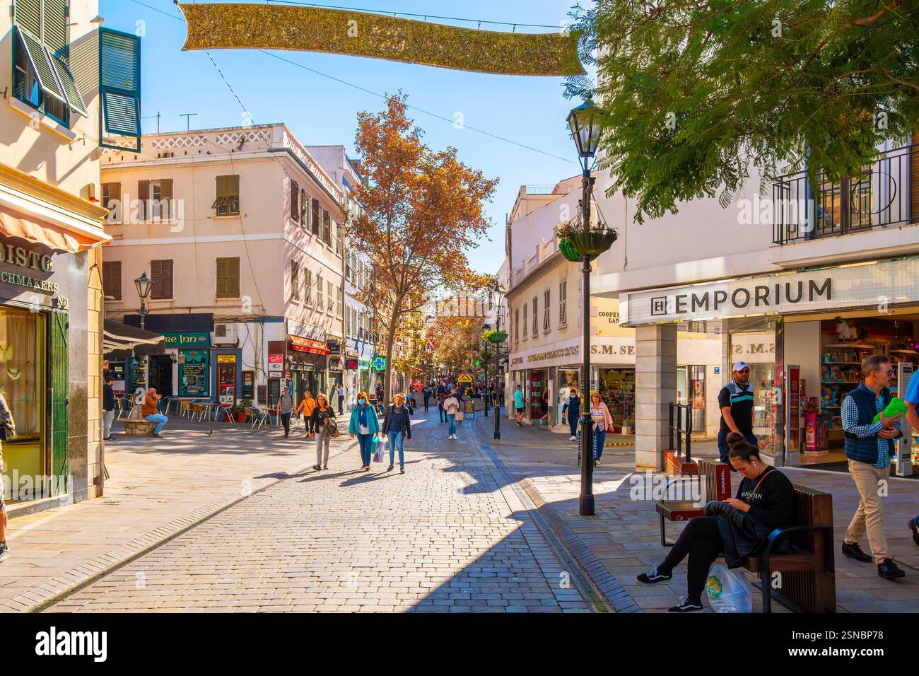 Les piétons passent devant des magasins vendant des articles hors taxes sur une rue principale décorée de vacances, la principale rue commerçante du centre de Gibraltar, au Royaume-Uni. Banque D'Images