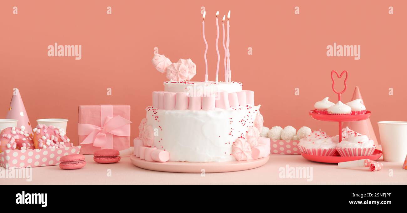 Gâteau d'anniversaire avec des bougies et des desserts sur la table blanche Banque D'Images