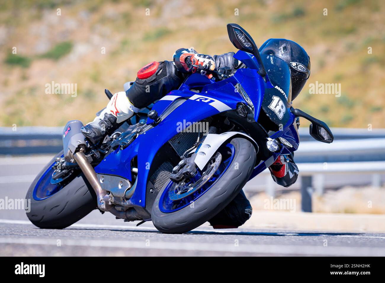 motocycliste prenant un virage serré dans la route par une journée ensoleillée. Photographie prise le 12 août 2023 dans la ville de Navalmoral de la Sierra, Avila, Espagne. Banque D'Images