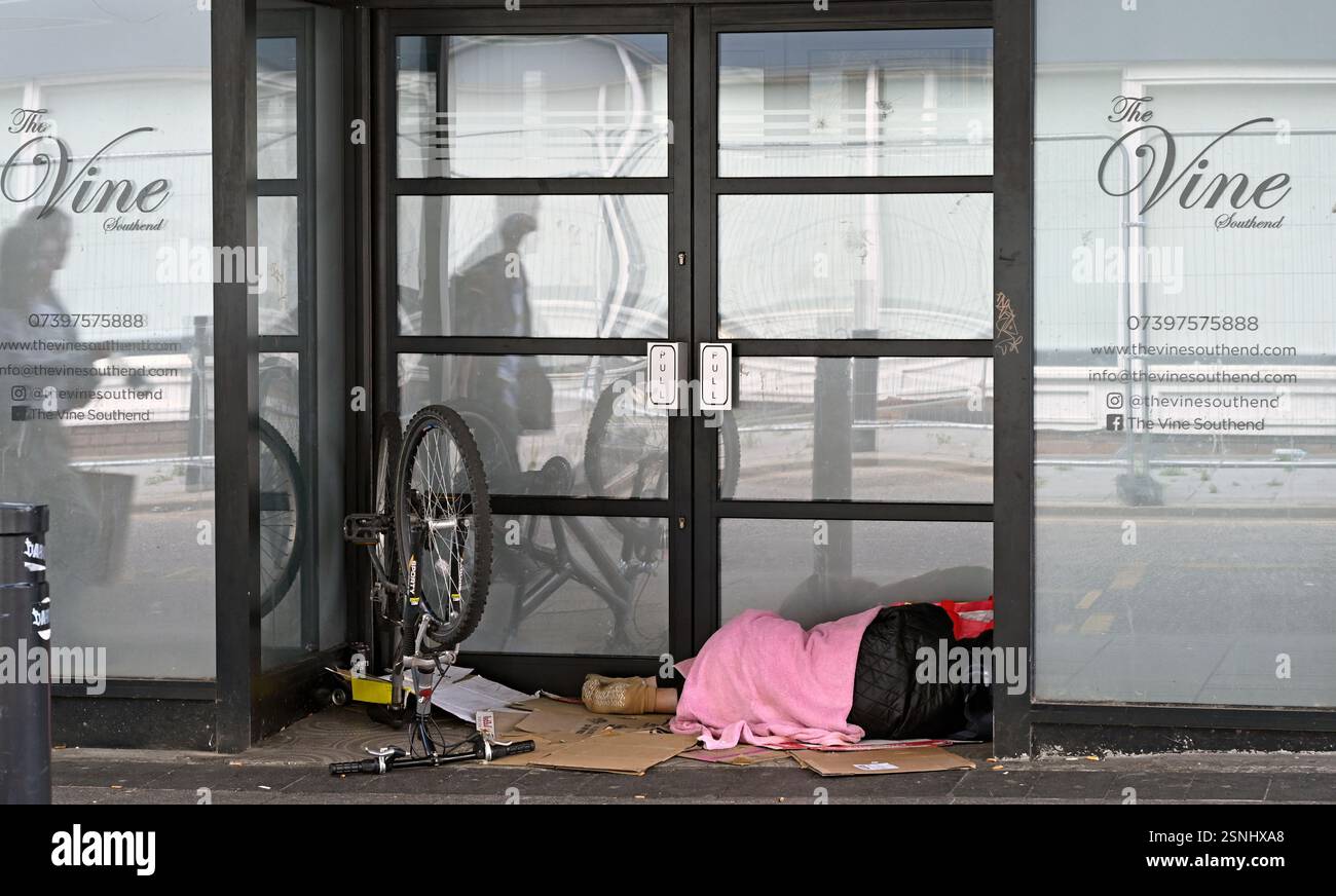 Une personne qui a un vélo dort dur dans une porte à Southend on Sea, ville de Southend. (vraisemblablement sans abri. pourrait être cycliste au repos). Banque D'Images