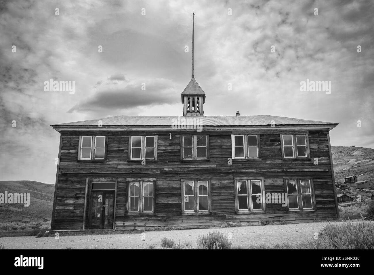 La vieille école en bois de deux étages dans la ville fantôme de Bodie. Noir et blanc. Banque D'Images